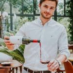 Fast Solutions - Een man schenkt wijn in een glas voor marketingdoeleinden in een webshop.