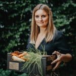 Fast Solutions - Een vrouw die een doos wortelen presenteert met expertise op het gebied van marketing.