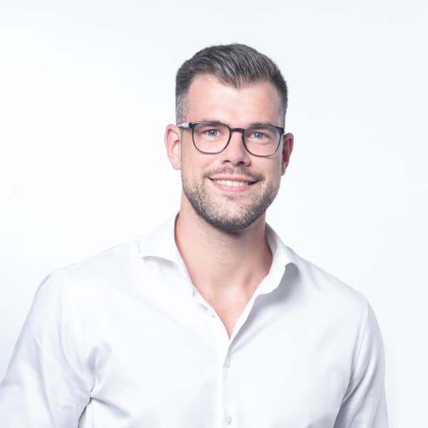 Fast Solutions - Een man met een bril en een wit overhemd met uitstekende vaardigheden op het gebied van marketing en webdesign.